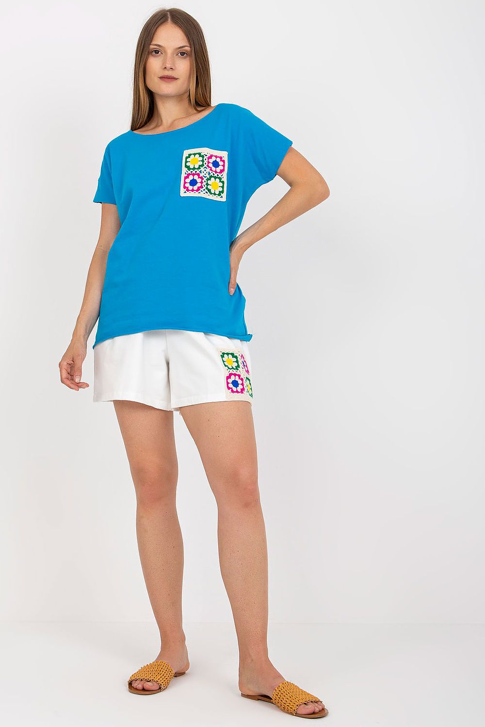Blue embroidered cotton summer set: tunic-style top and white shorts with colorful motifs.