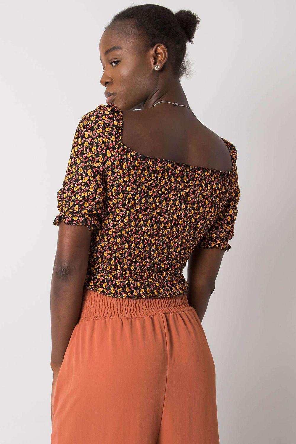 Back of black floral blouse with off-shoulder neckline and puff sleeves