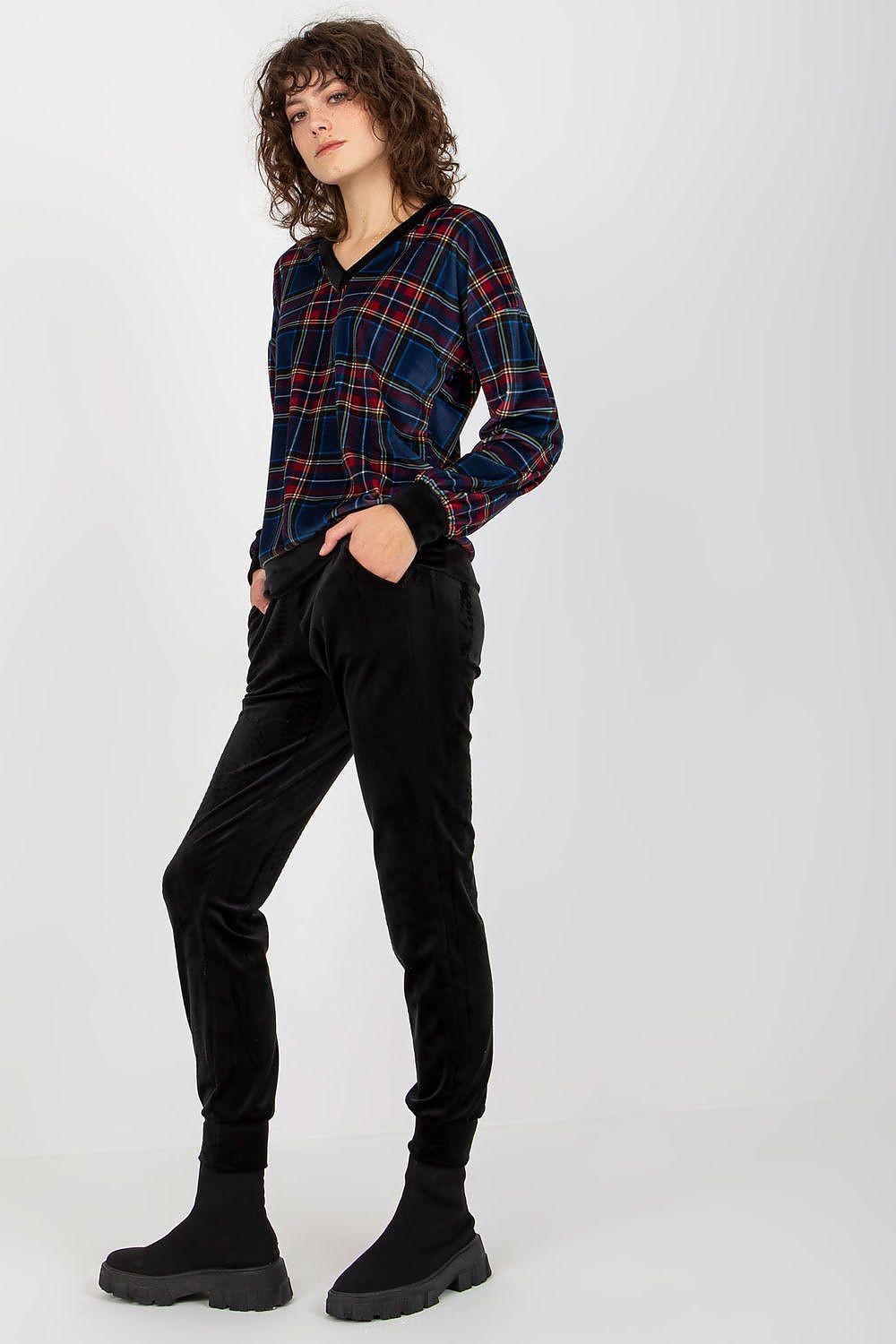 Red, green, and blue plaid long-sleeve top with black jogger pants set, standing