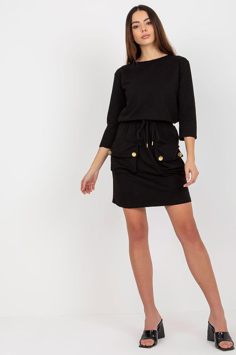 Black daydress with three-quarter sleeves, cinched waist and gold button pockets