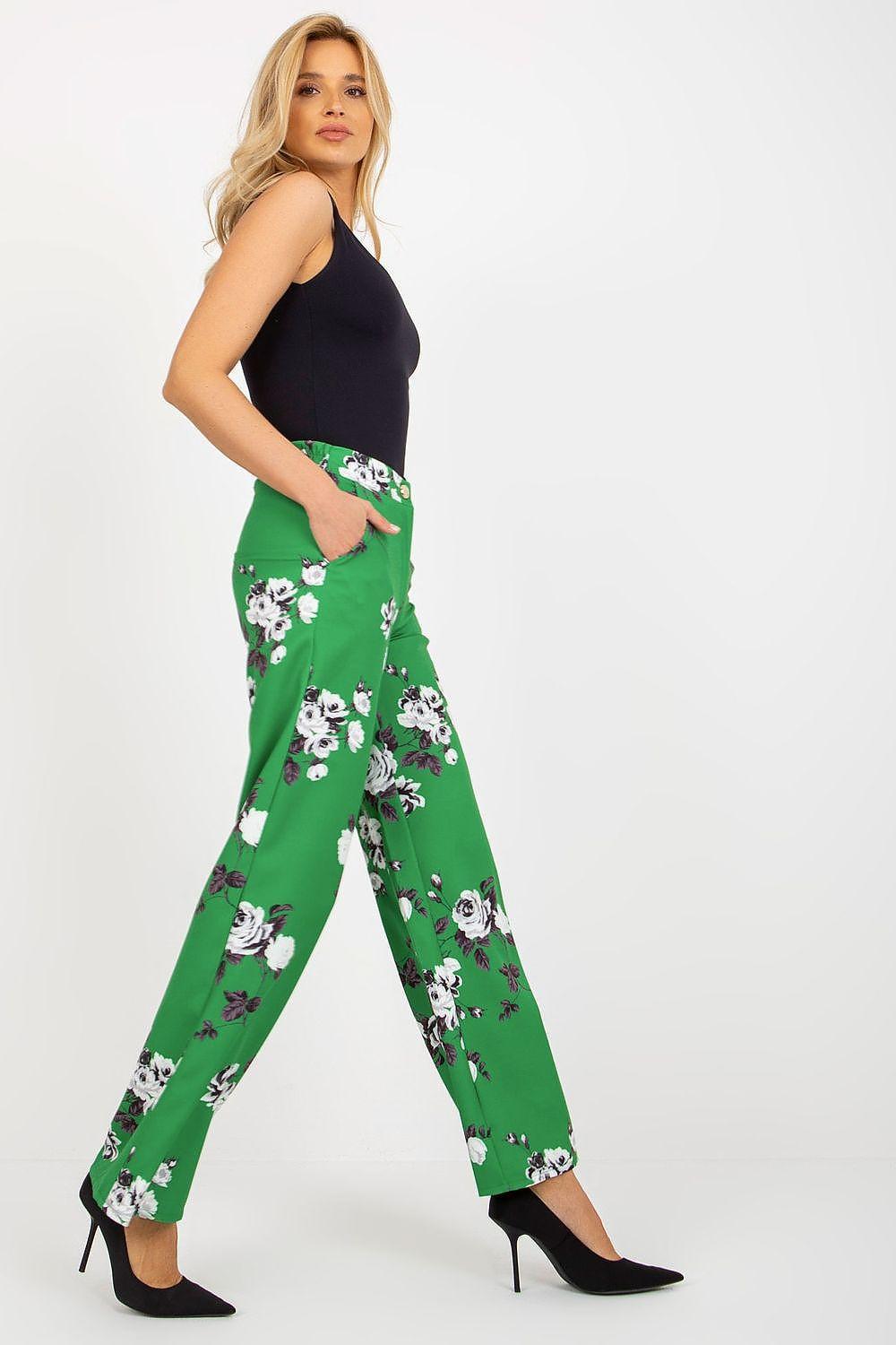 Green women's trousers with white floral print and wide legs, full length.