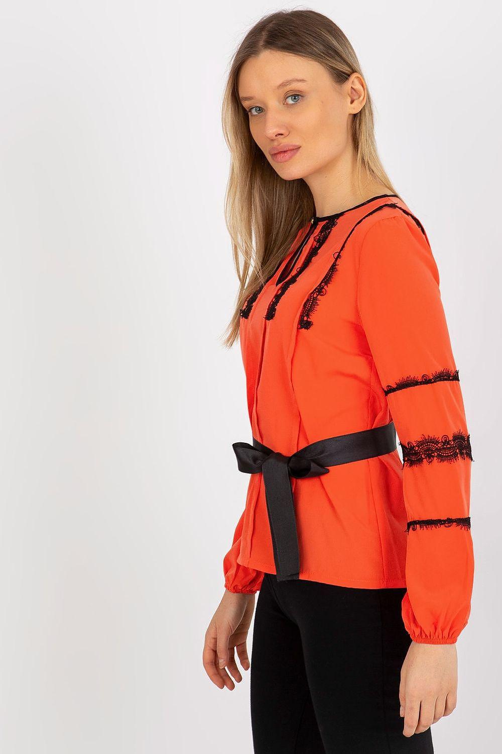 Orange blouse with black waist tie belt and stripe trim on long sleeves