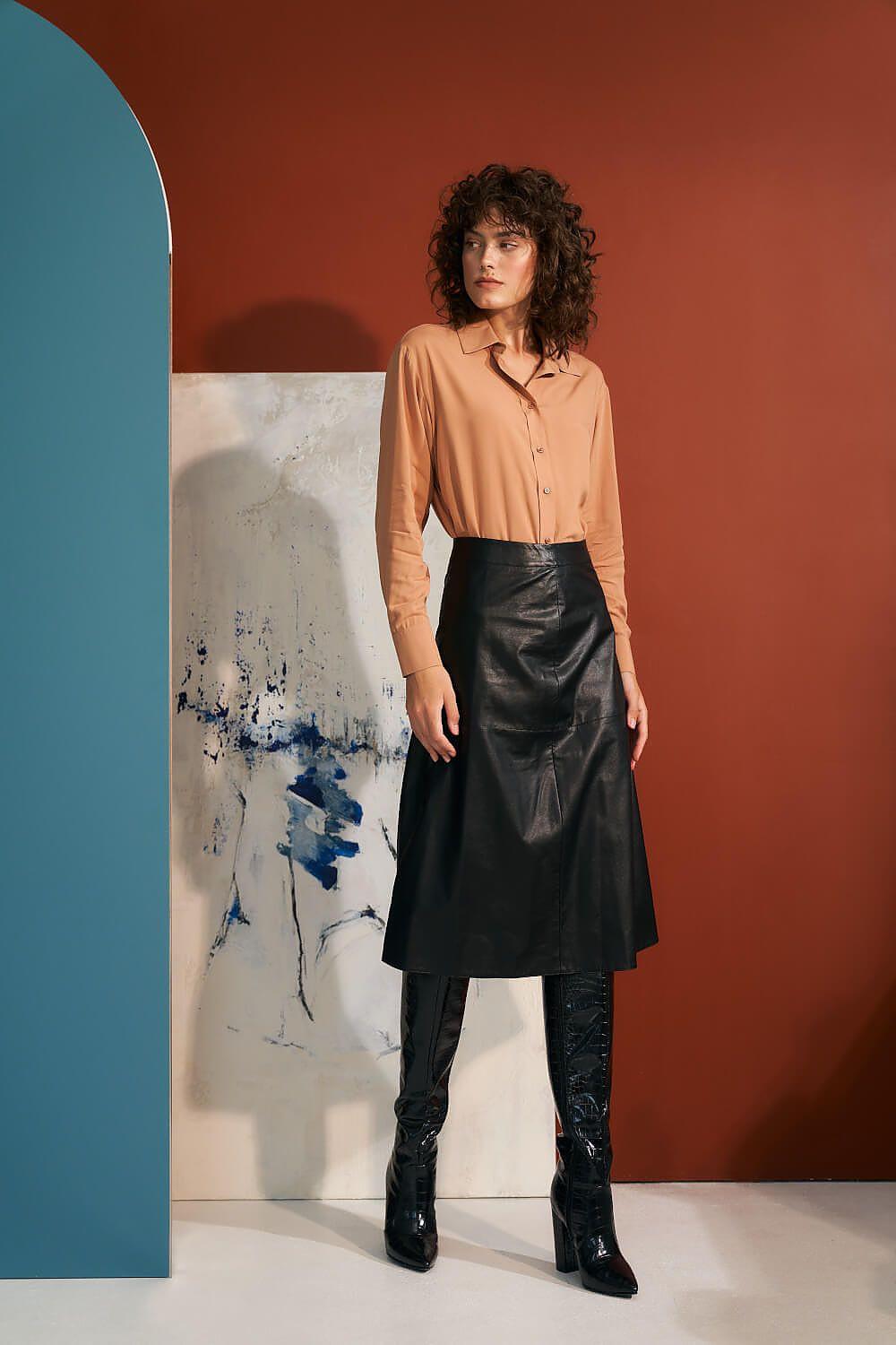 Black faux leather trapeze skirt with mid-calf length and flared A-line shape