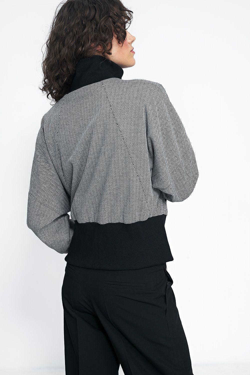 Back view of gray herringbone short jacket with full zipper and black trim