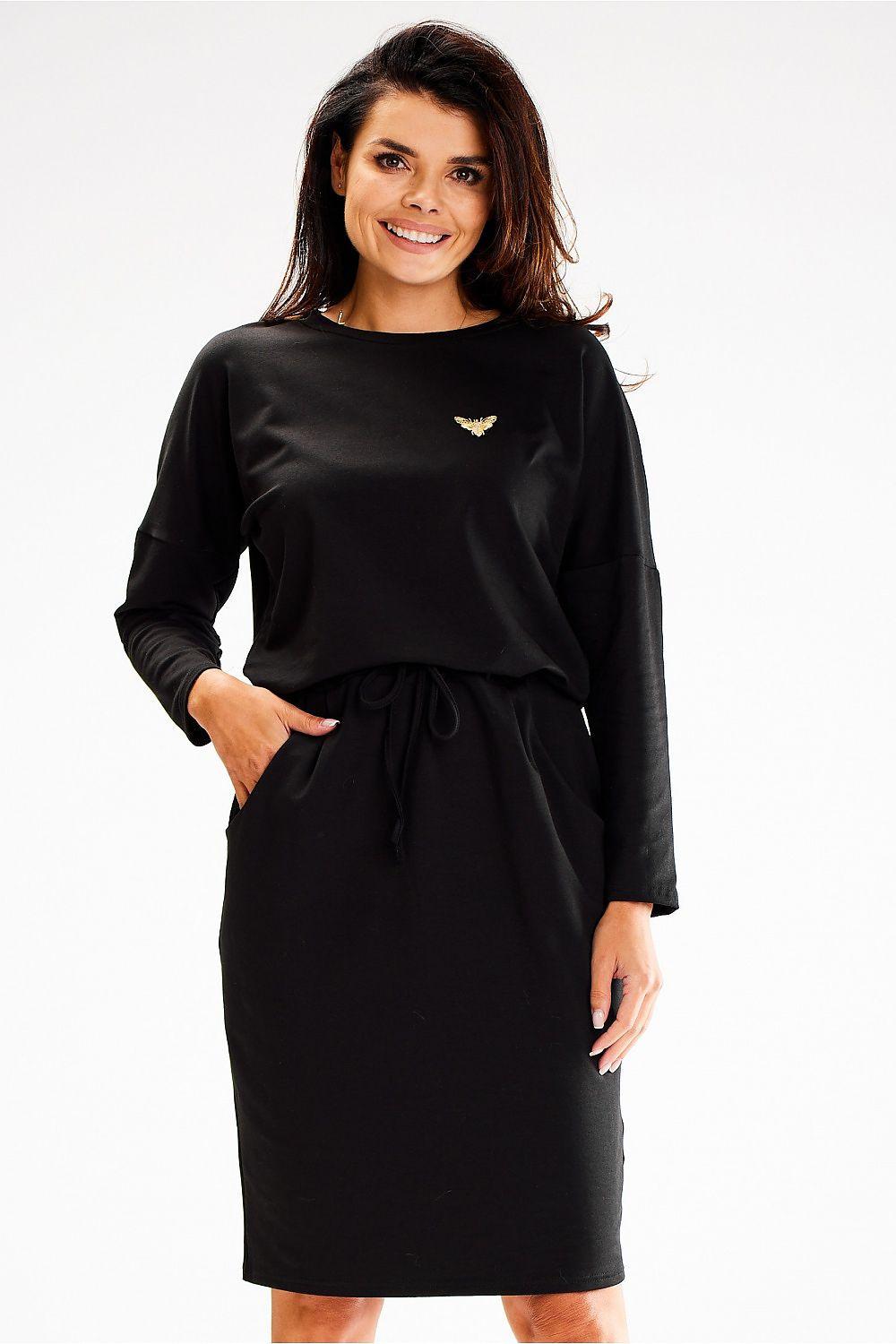 Black daydress with long sleeves, round neckline, and tied waist belt
