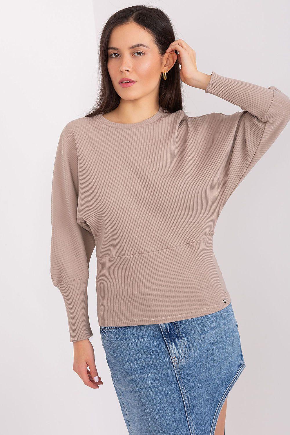 Beige ribbed cotton blouse with batwing sleeves and crew neck, worn with blue jeans