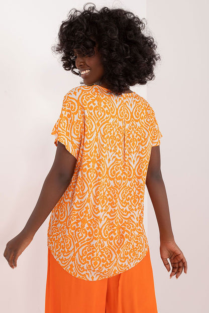 Orange patterned blouse back with short sleeves and flowing drape