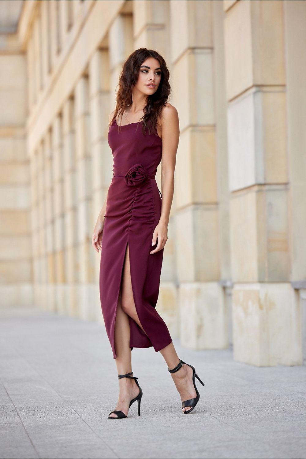 Sleeveless midi cocktail dress with ruched waist and front slit, rose-detail at hip, dark wine.