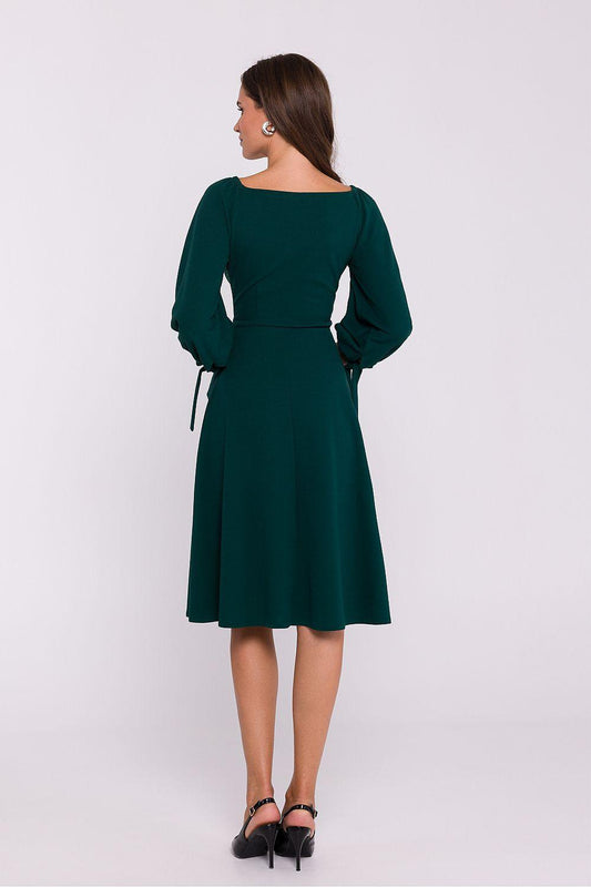 Green V-neck daydress with long sleeves and tie cuffs, back view, knee-length flare.