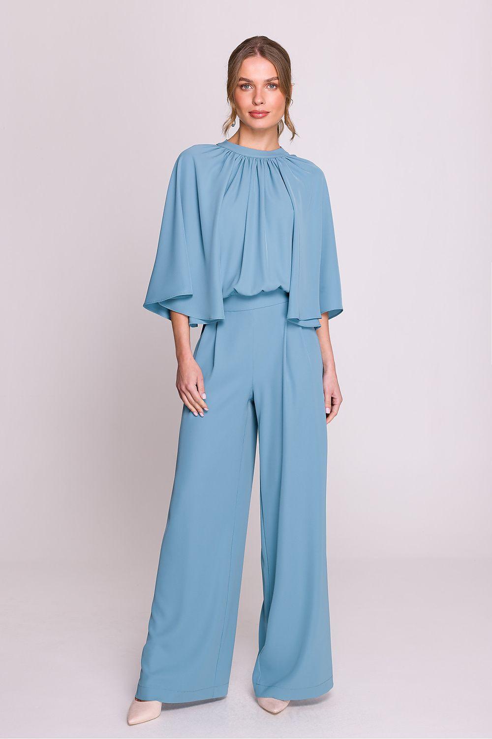 Blue wide-leg suit with draped cape sleeves and tiered peplum top, matching trousers