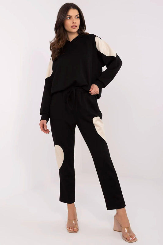 Black two-piece tracksuit set with hoodie and slim pants, cream patch details