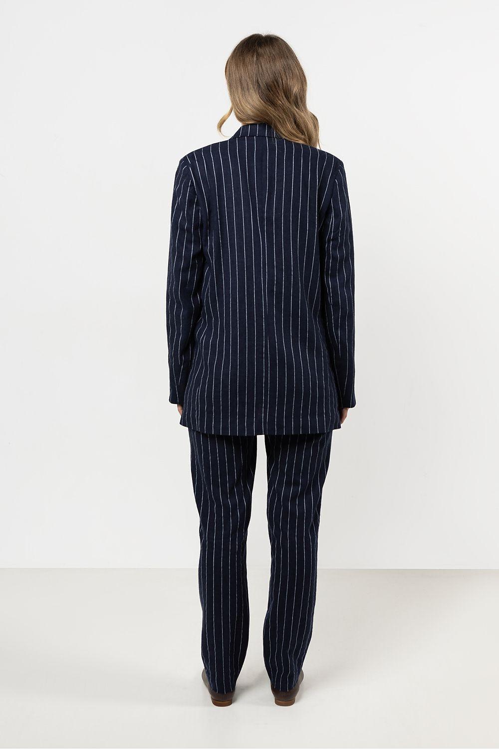 Women’s navy pinstripe trousers from back view, tapered legs to ankle hem