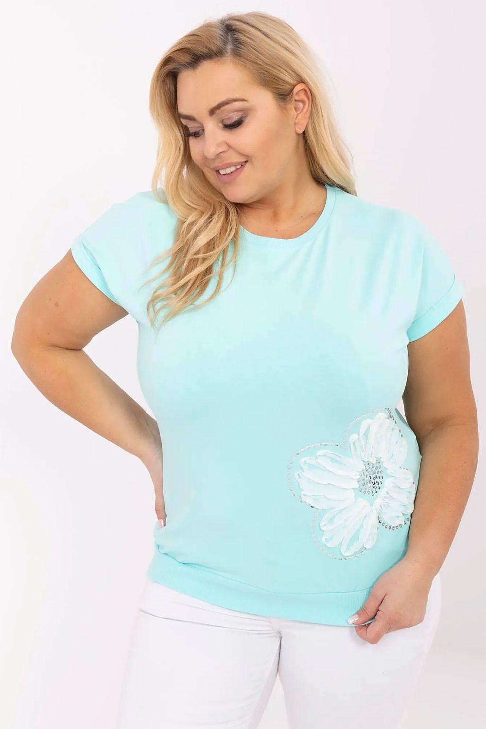Plus size blouse in light teal with short sleeves and sequin floral applique on hem
