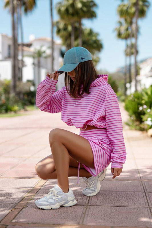 LaBalancia pink striped hoodie and shorts set with blue cap, kneeling
