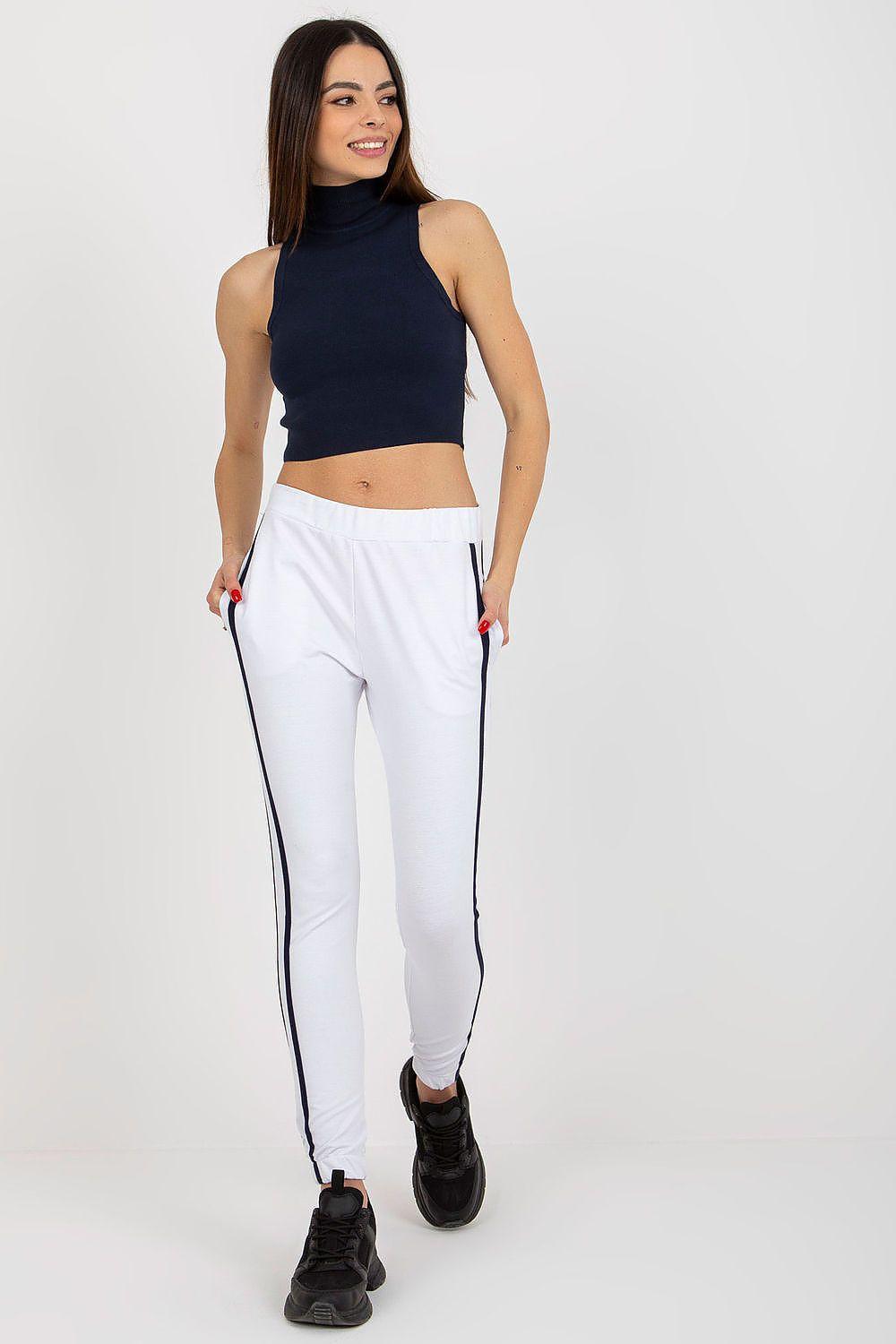White tracksuit trousers with navy side stripes, elastic waistband, ankle-length