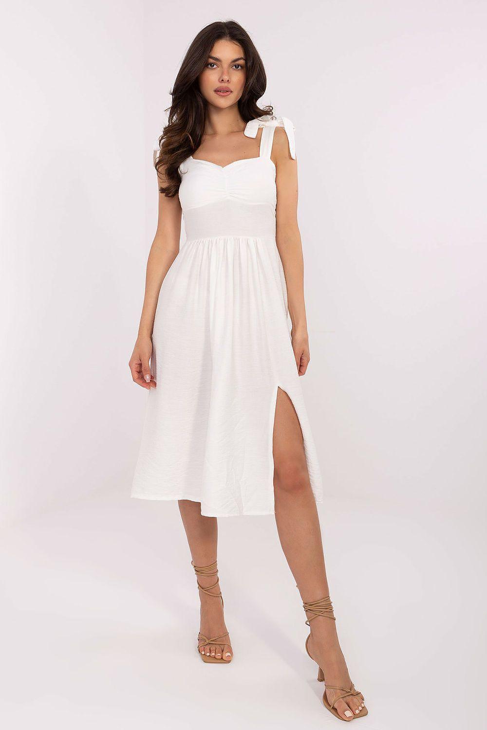 White daydress with square neckline, bow shoulder straps, smocked waist and side slit.