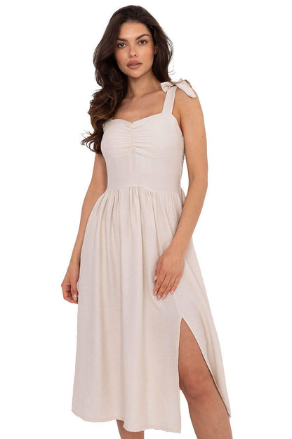 White daydress with square neckline, bow shoulder straps, smocked waist and side slit.