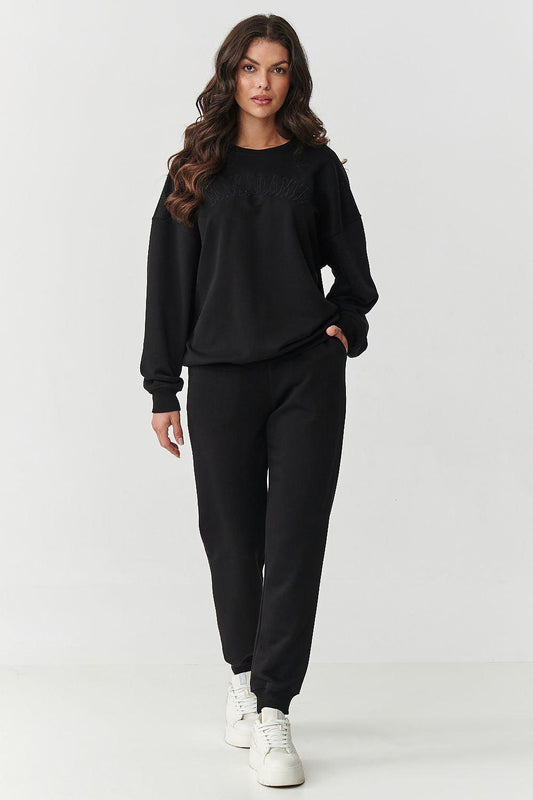 Black crewneck sweatshirt and jogger pants set, long sleeves and cuffed hems.