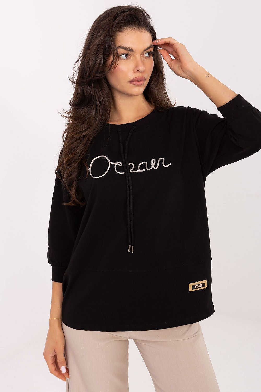 Black cotton blouse with hood, long drawstrings, and embroidered script on the front
