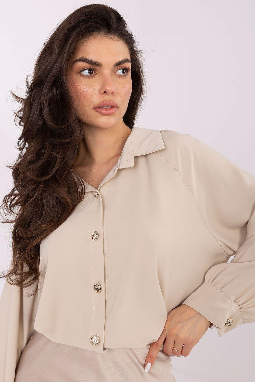Beige long-sleeve button-front shirt with pointed collar and buttoned cuffs.