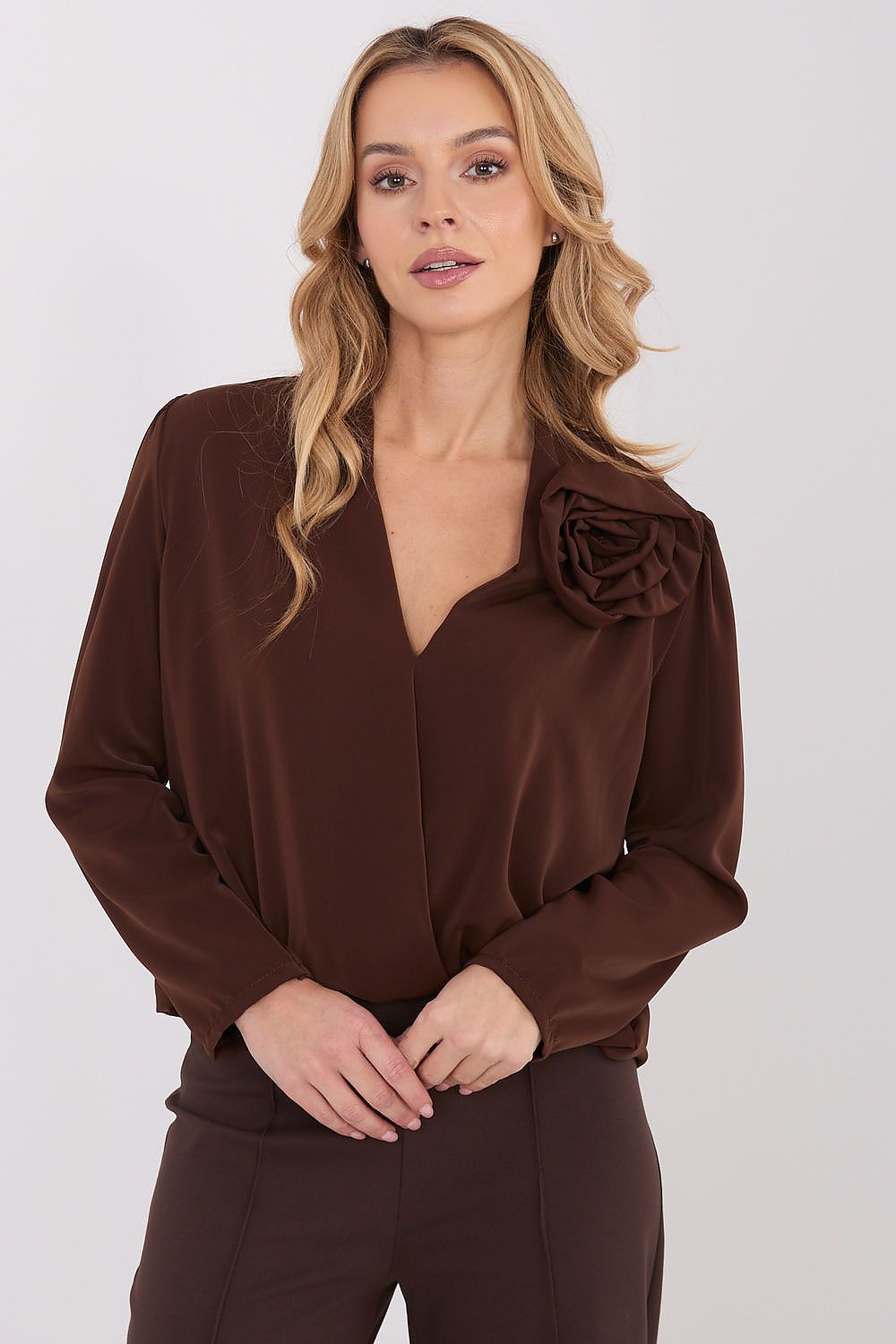 Brown long-sleeve blouse with V-neck and large rosette shoulder detail