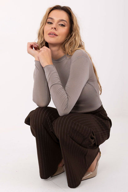 Taupe long-sleeve blouse with crew neck, fitted bodice, and clean hemline