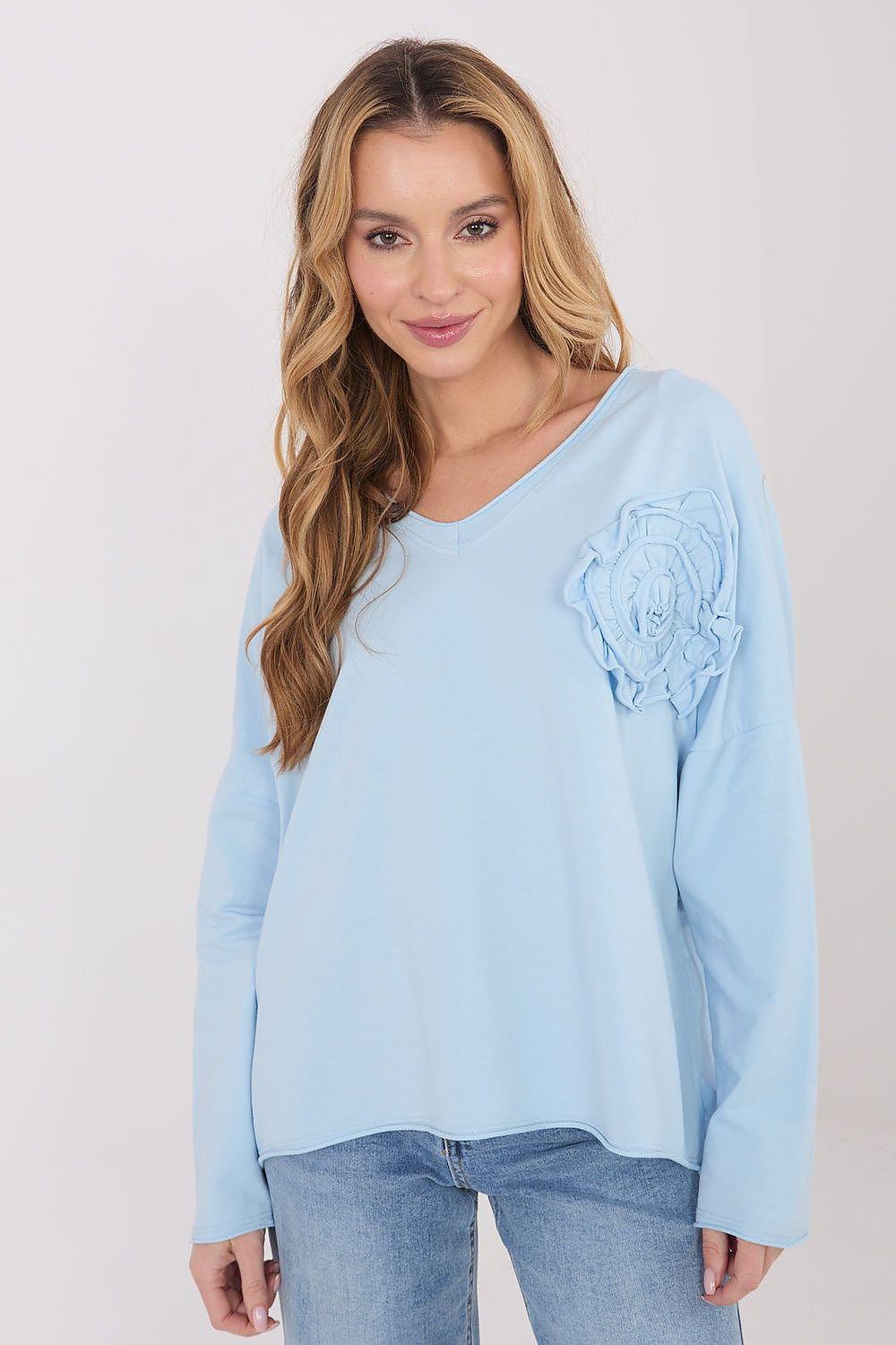 Light blue V-neck blouse with long sleeves and rosette applique at the shoulder
