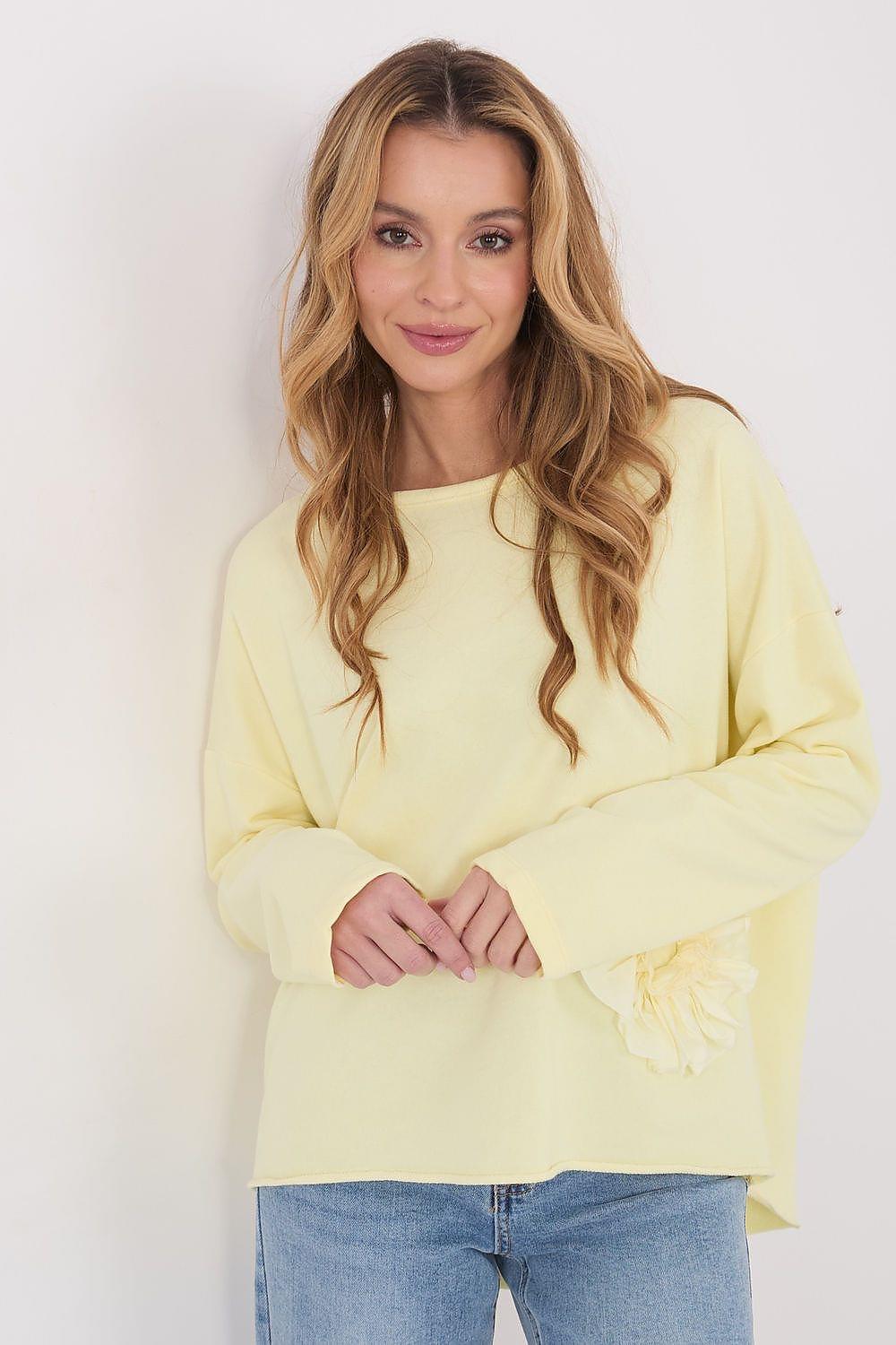 Yellow long-sleeve blouse with round neck and floral applique on the chest.