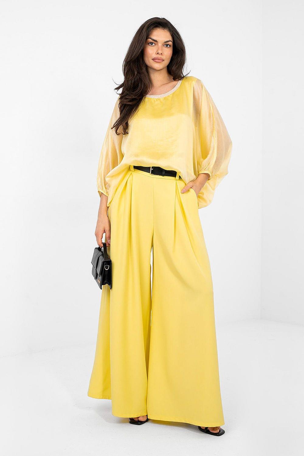 Yellow blouse with loose fit, round neckline, and billowy sleeves with gathered cuffs