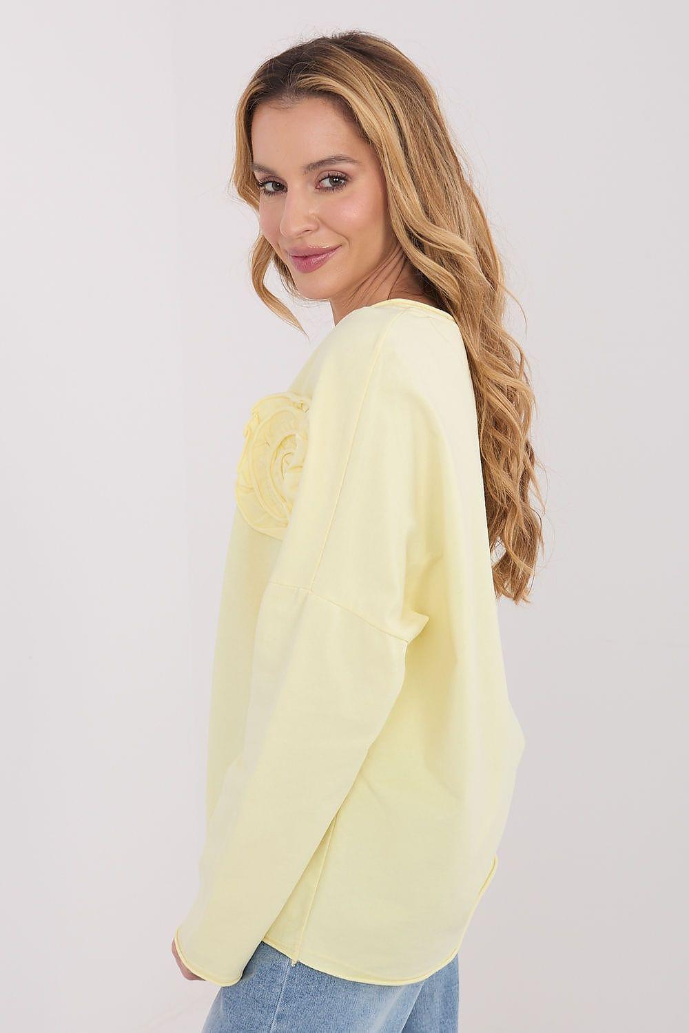 Yellow long-sleeve blouse side view with rosette applique on the front