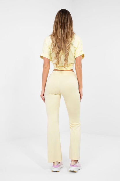 Yellow flared tracksuit trousers with elastic waistband, slim-to-wide leg, back.