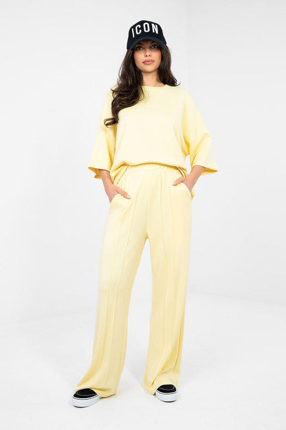 Pale yellow wide-leg tracksuit trousers with elastic waistband, full length