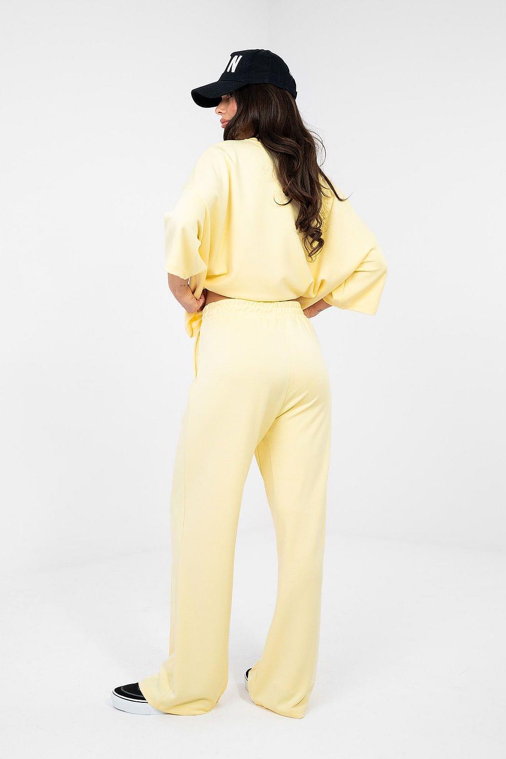 Pale yellow tracksuit trousers with elastic waistband, wide-leg back view