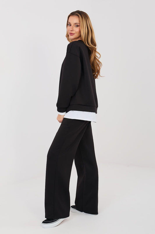 Black sweatshirt and wide-leg pants set shown from the side with white hem band