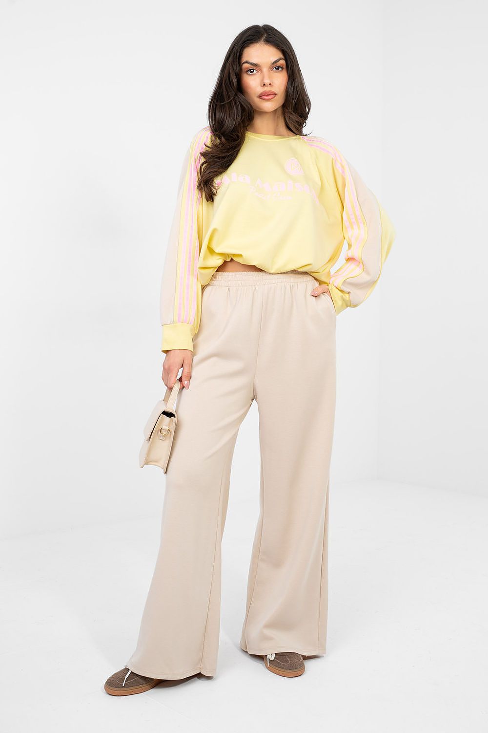 Two-piece lounge set with yellow long-sleeve top and beige wide-leg trousers, tie waist
