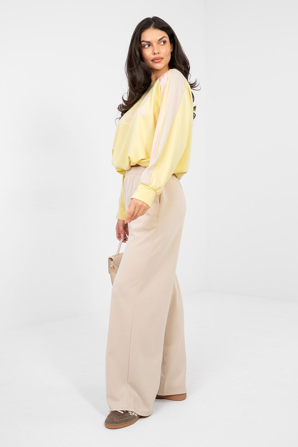 Two-piece lounge set: pale yellow blouse with cuffed sleeves and beige wide-leg pants