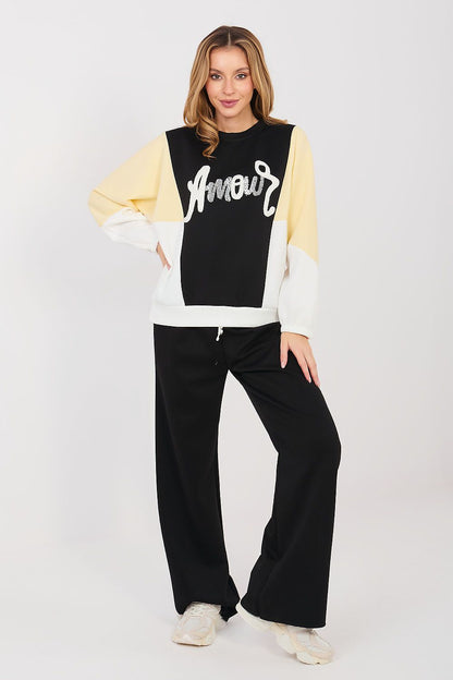 Black sweatshirt and pants set with cream sleeves and wide-leg black trousers