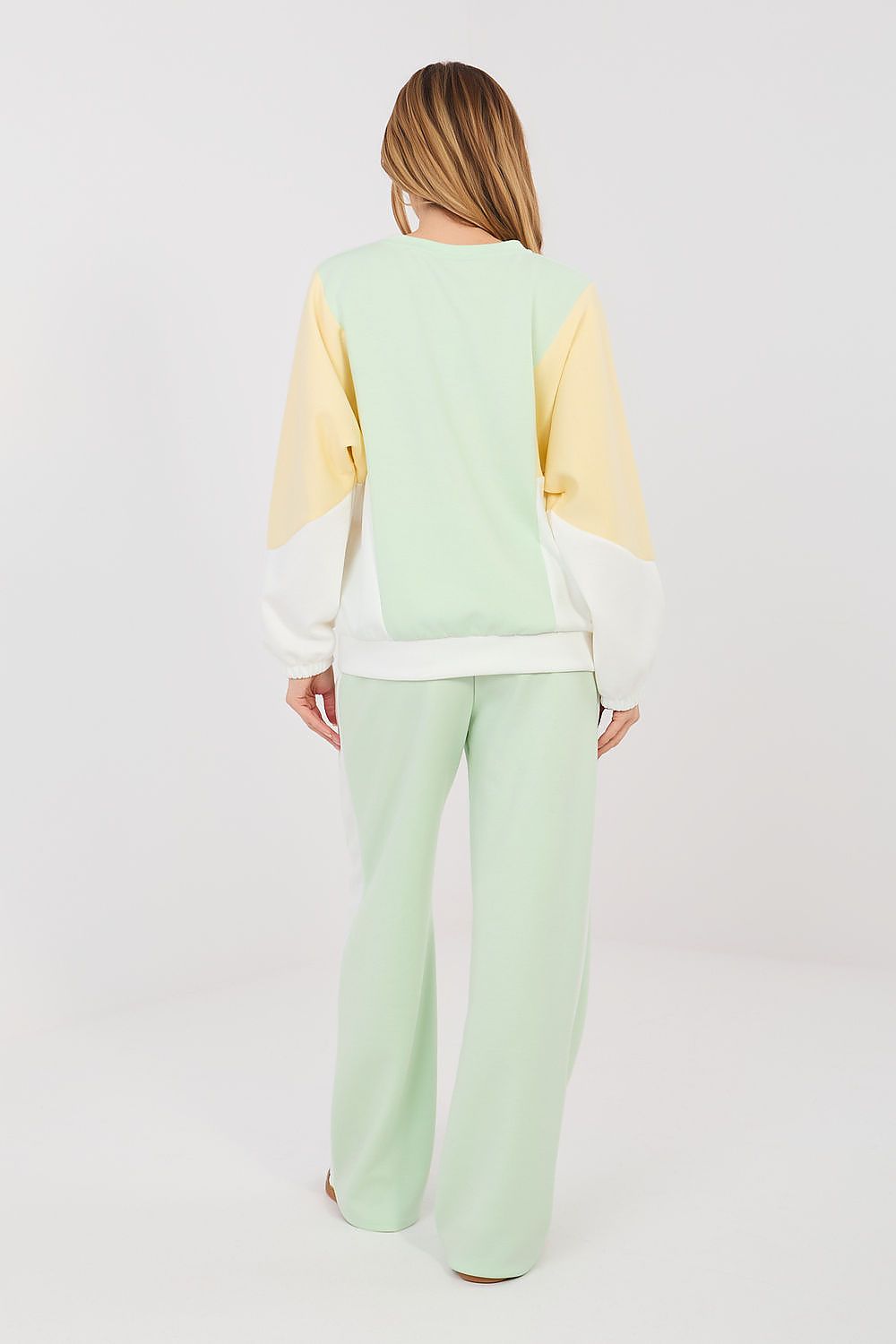 Back view of sweatshirt and pants set in pale yellow with mint-green trousers