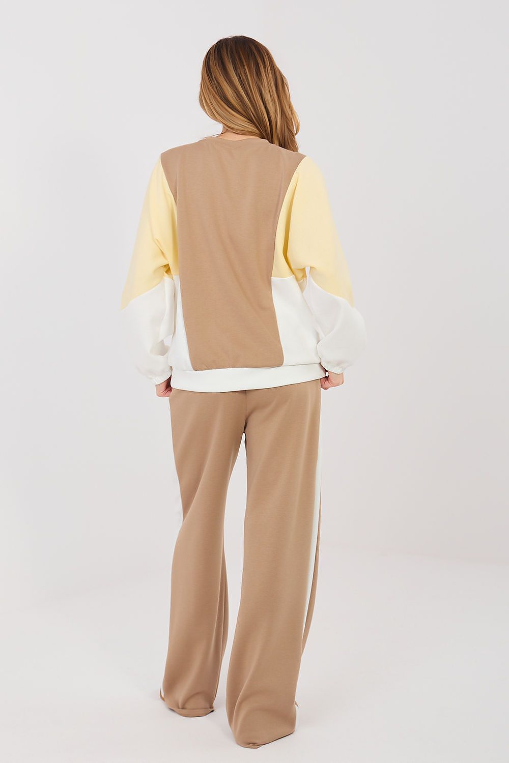 Back view of beige sweatshirt and matching flared pants set with cream sleeves
