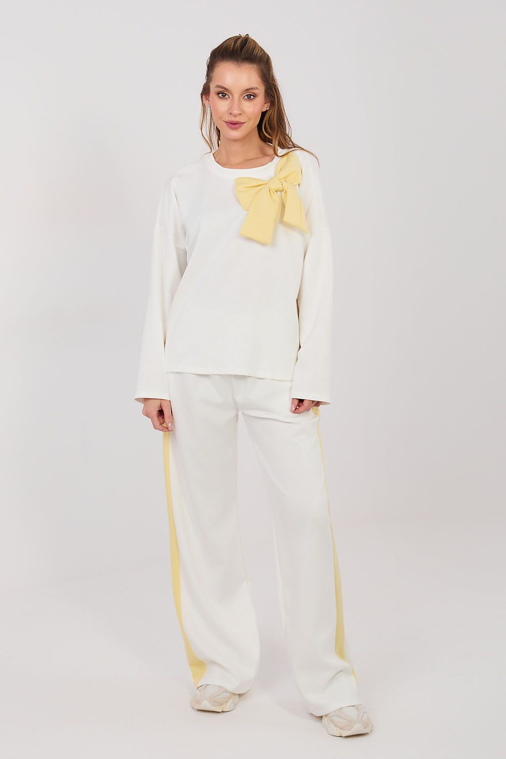 White two-piece set with long-sleeve blouse and wide-leg pants, yellow bow detail