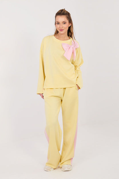 Yellow two-piece set with long-sleeve blouse and wide-leg pants, pink bow detail