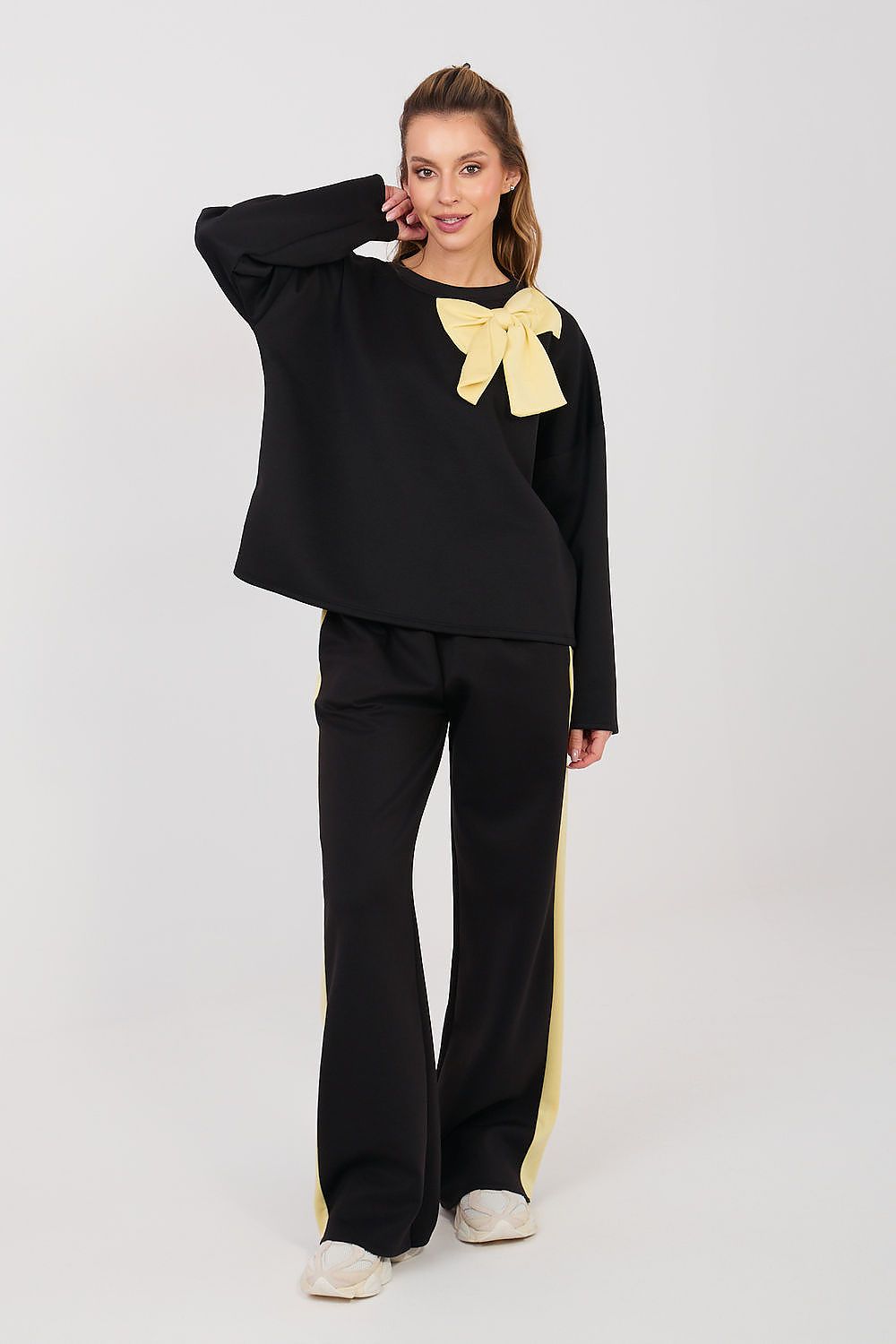 Black two-piece set with long sleeves, yellow bow at neckline, wide-leg pants