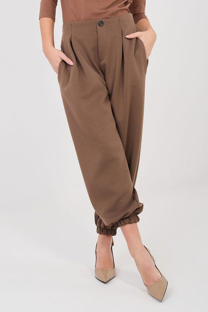 Brown tracksuit trousers with elastic waist and ankle cuffs, side pockets.