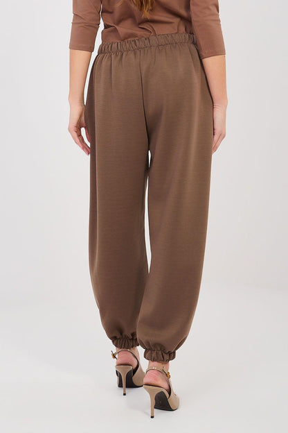 Brown tracksuit trousers with gathered elastic cuff and stitched front seam.