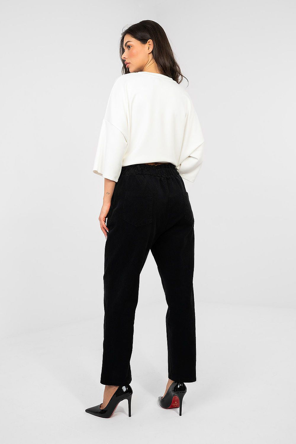 Black corduroy trousers with belt loops and straight leg, seen from back