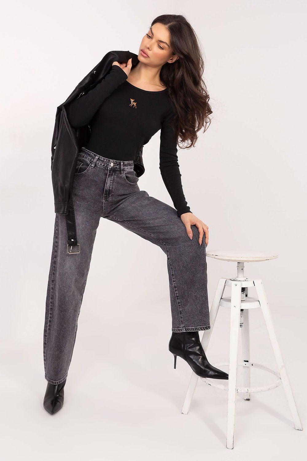 Black long-sleeve blouse with small chest emblem and fitted waist