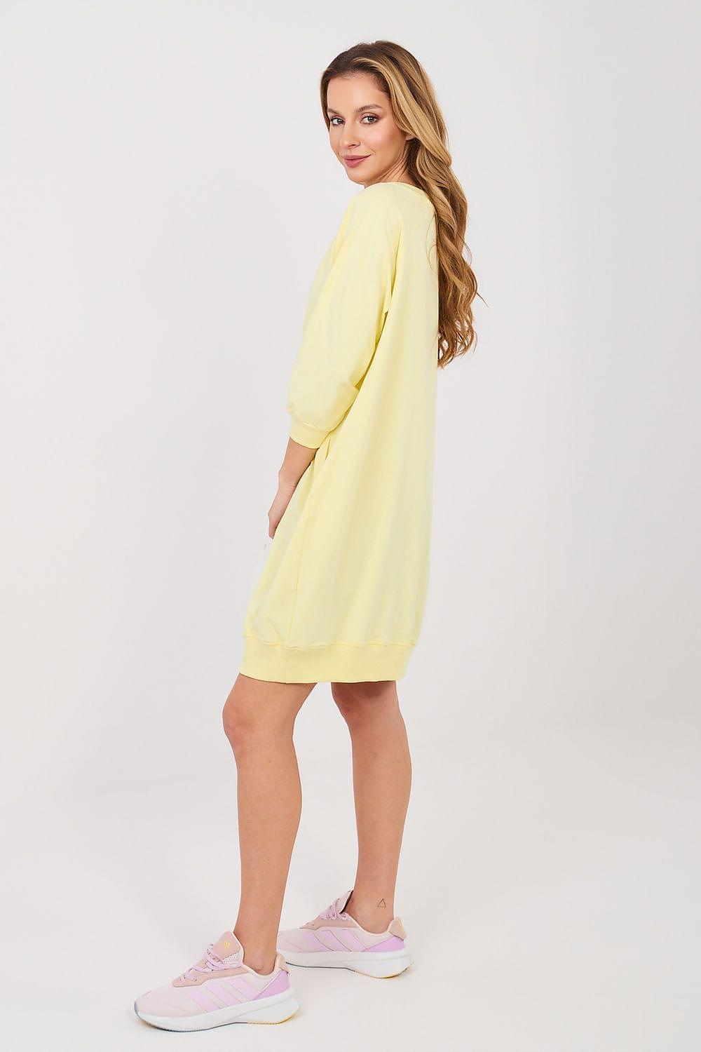 Yellow daydress with V-neck and three-quarter sleeves, side view above-knee length.