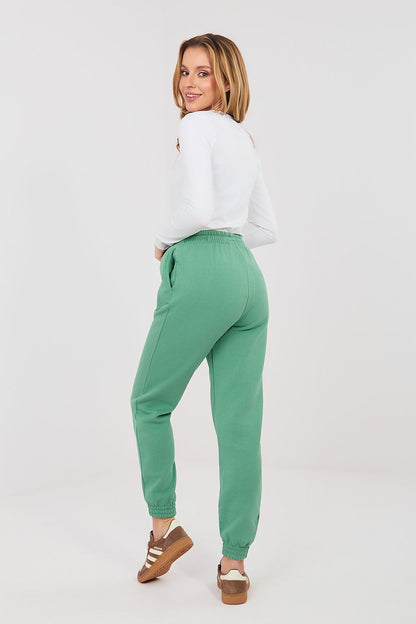 Green tracksuit jogger trousers, back view with drawstring waist and ankle cuffs.