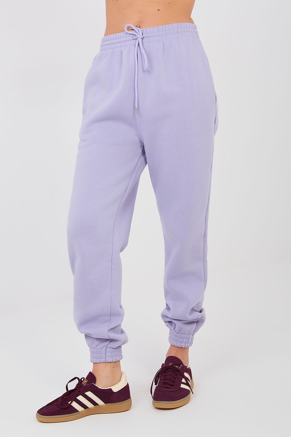 Lavender tracksuit trousers with drawstring waist and elastic ankle cuffs, front view.