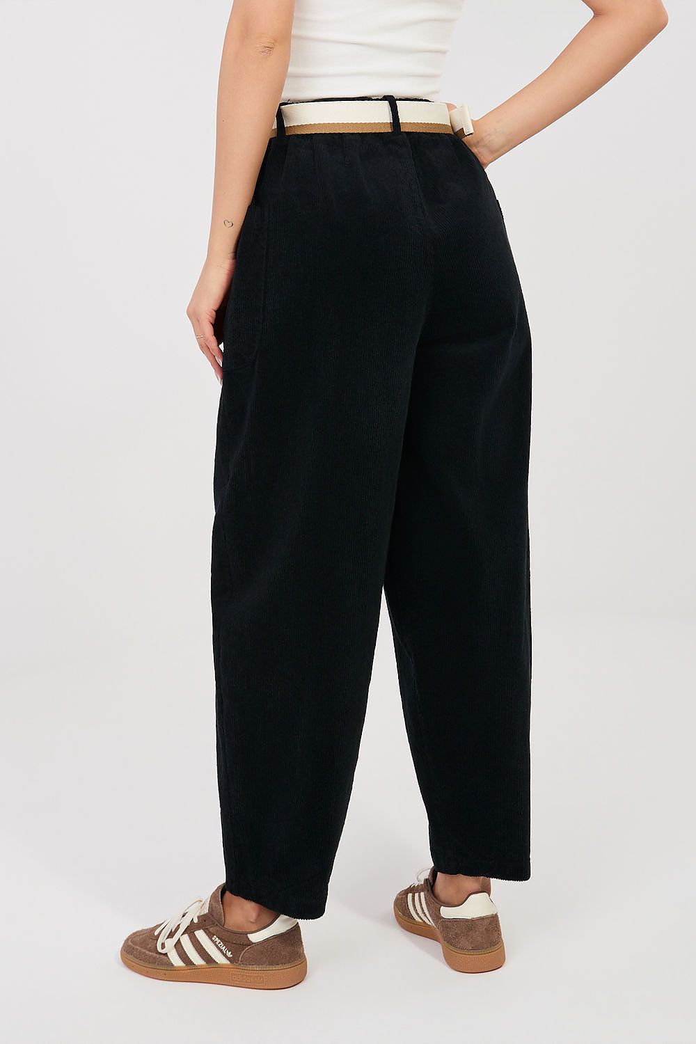 Corduroy trousers in black corduroy, front view with belted waistband and cuffed hems